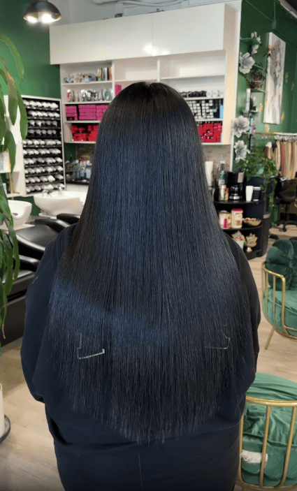 Back view of long dark hair left smooth and glossy after a keratin treatment at Bellisimo Salon & Boutique in San Marcos